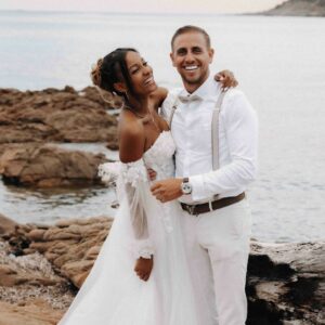 Jeunes mariés vêtu de blanc en photo avec la mer en fond