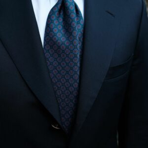 Cravate bleu nuit avec des point style mandala orange et bleu porter avec un costume bleu marine t chemise blanche