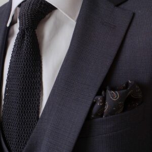 Cravate en maille noir porter avec un costume noir et chemise blanche