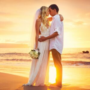 Jeunes marié shooting photo sur la plage avec un beau couché de soleil